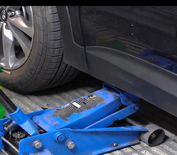 عکس بالا بردن خودرو برای آموزش نحوه نصب ضربه گیر کمک فنر TTC توسط جک